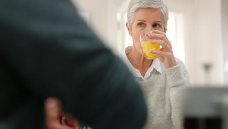 Gesunde-ältere-Frau-Mit-Orangensaft-Im-Gespräch