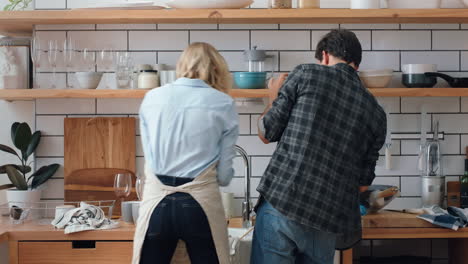 Young-couple-playing-with-soap-bubbles-in-kitchen