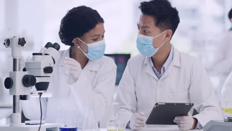 Two-medical-scientists-using-a-tablet