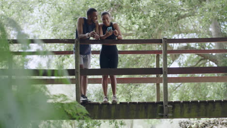 Active-couple-resting-on-a-bridge-after-exercising