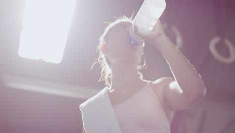 Active-young-woman-drinking-water-during-a-break