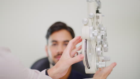 Optometrist-using-eye-phoropter-machine-to-examine