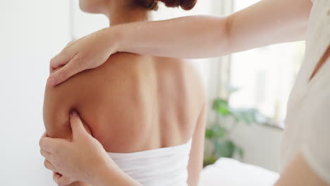 Back-and-shoulder-of-woman-being-massaged-by-hands
