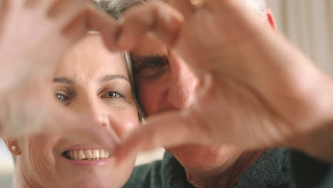 Senior-couple-doing-a-heart-shape-with-their-hands