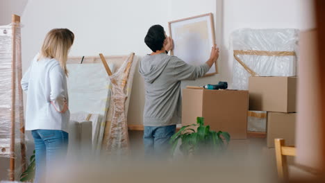 Homeowner-couple-with-wall-picture-frame-moving