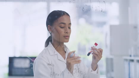 Female-scientists-writing-formula-on-a-clear-glass