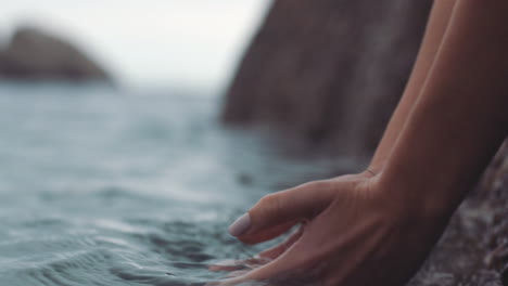 Woman-hands-in-the-water-from-the-ocean-waves