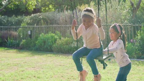 Two-children-playing-on-a-swing-in-their-backyard