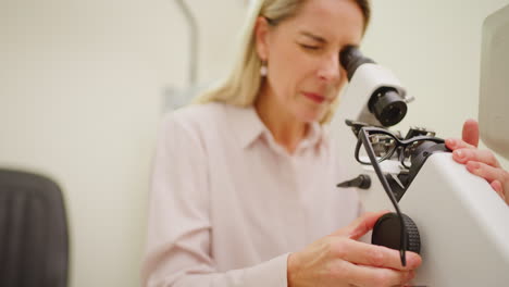 An-optometrist-using-a-microscope-to-examine