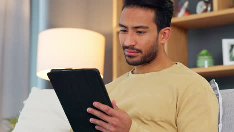 Relaxed-young-man-reading-an-ebook-on-his-digital