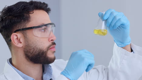 Serious-male-scientist-analyzes-liquid-in-a-beaker