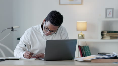 Black-business-man-writing-notes-while-working