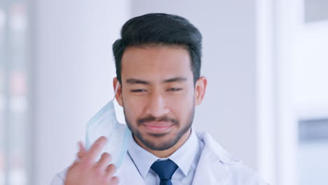 Portrait-of-doctor-taking-face-mask-off-as-sign