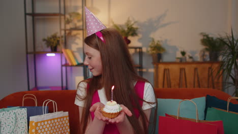 Fröhliches-Kind-Feiert-Geburtstagsfeier-Und-Wünscht-Sich,-Brennende-Kerze-Auf-Kleinen-Cupcake-Zu-Blasen