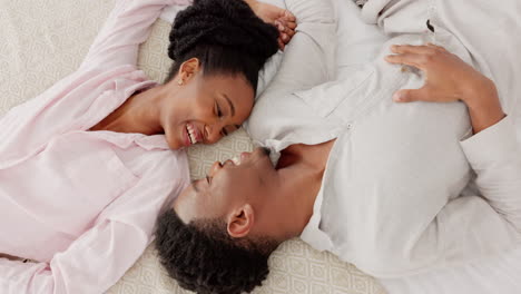 Happy-black-couple-bonding-in-bed,-talking