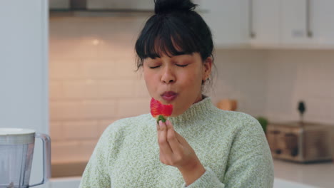 Woman-in-kitchen-happy-while-eating-strawberry