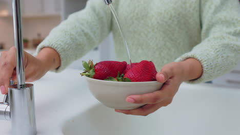 Hände-Einer-Frau,-Die-Erdbeeren-Mit-Wasser-Reinigt
