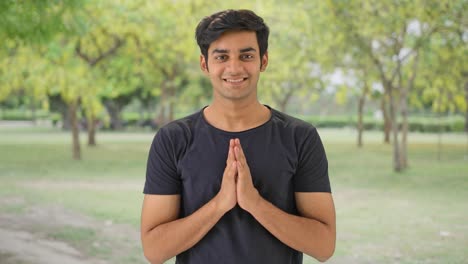 Cute-Indian-boy-doing-Namaste-in-a-park