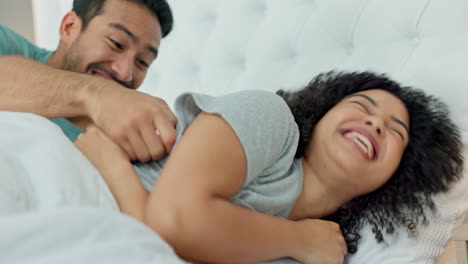 Bedroom-fun,-laugh-and-silly-couple-lying-in-bed