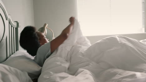 Bed,-sleep-and-stretching-by-black-woman-waking-up