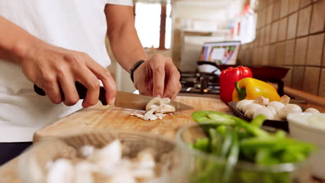Chef-hands,-knife-and-vegetables-on-chopping-board