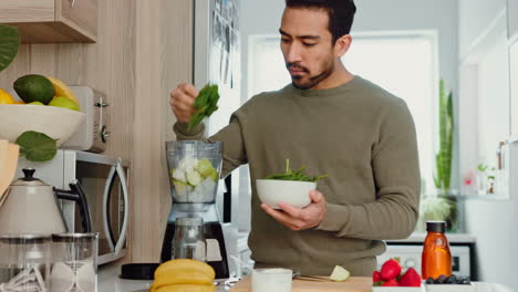 Man-makes-a-healthy-smoothie-in-kitchen-with-fruit