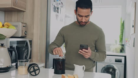 Asian-man,-coffee-or-phone-in-house-kitchen