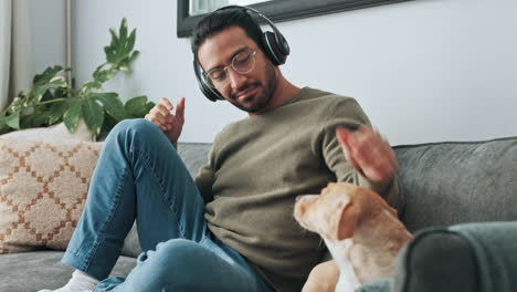 Man,-phone-and-headphones-on-sofa-with-dog