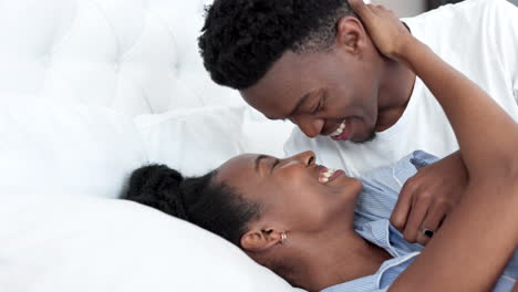 Happy-black-couple-in-bedroom-kiss