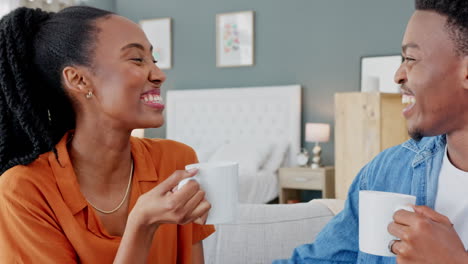 Happy-black-couple-with-a-cup-of-coffee-on-a-sofa