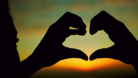 Silhouette,-love-and-heart-hand-with-sunset-clouds