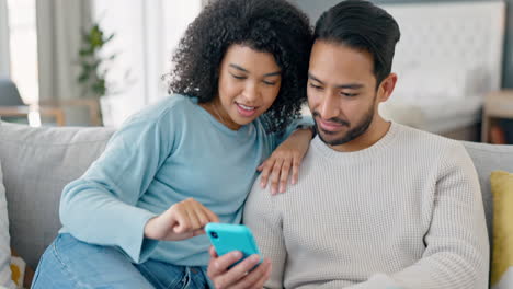 Happy-multiracial-couple-on-couch-with-phone