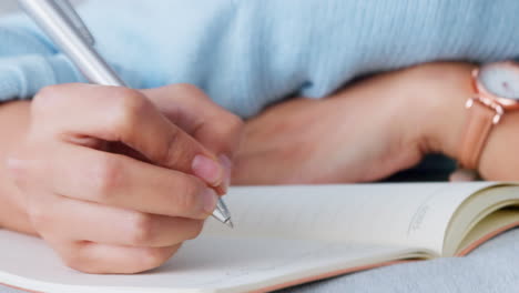 Woman-hands-writing-in-notebook