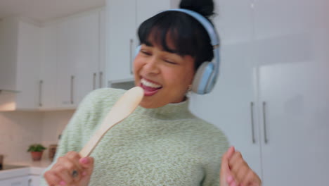 Cooking,-singing-and-headphones-with-woman