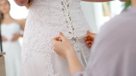 Freunde-Helfen-Frau-Beim-Hochzeitskleidknoten