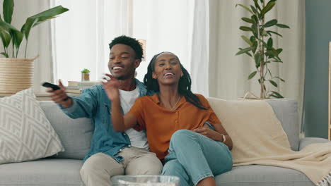Black-couple,-laughing,-and-tv-play-fight-over