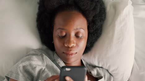 Woman-with-phone,-in-bed-and-online