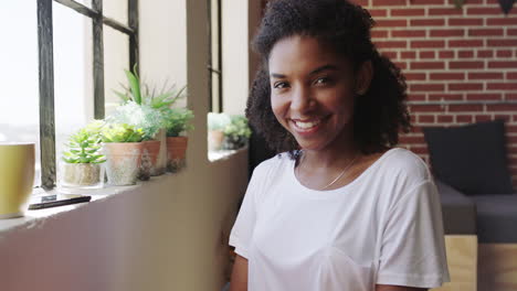 Black-woman,-relax-and-smile-by-apartment-window