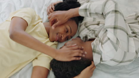 Kiss,-above-and-African-couple-on-a-bed-for-love