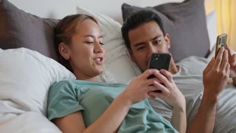 Glückliches-Junges-Paar-Im-Bett,-Das-In-Sozialen-Netzwerken-Telefoniert