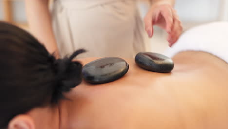 Hands,-massage-therapist-or-hot-stone-in-spa