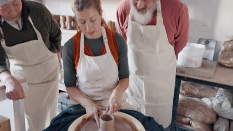 Pottery,-group-and-teacher-mold-clay-in-studio