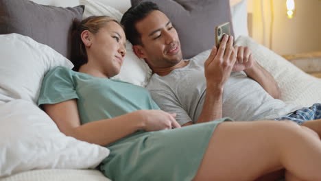 Couple-in-bed,-social-media-with-smartphone