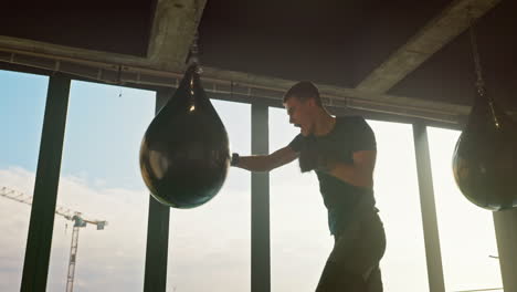 Man,-boxing-bag-and-punching-in-gym-workout