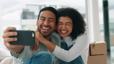 Couple,-moving-and-selfie-in-new-home-to-celebrate