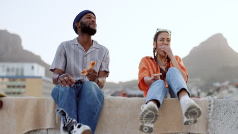 Couple,-pizza-eating-or-laughing-on-city-rooftop