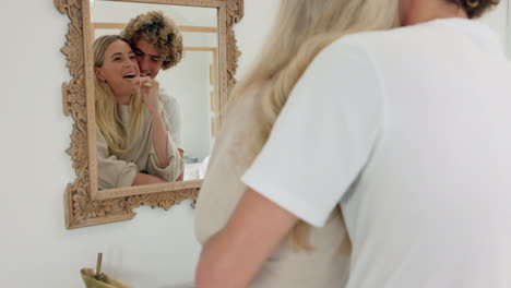 Couple,-hug-and-brushing-teeth-in-bathroom-mirror