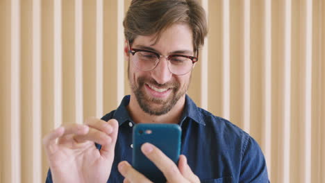 Hombre-Con-Gafas-Y-Teléfono-Para-Desplazarse-En-Las-Redes-Sociales