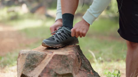 Sports-shoes,-hiking-and-man-tie-lace-on-rock