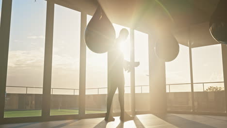 Boxer,-fitness-and-punching-bag-by-man-at-sunrise